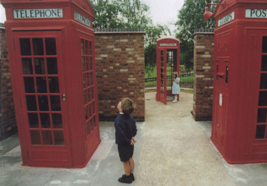 Children exploring the kiosk courtyard, including a K4 post-and-telephone box