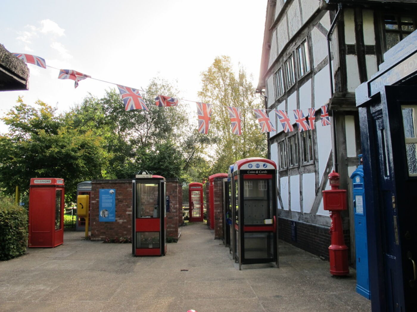 Overview of the kiosk collection courtyard, with red kiosks, a blue police box and bunting